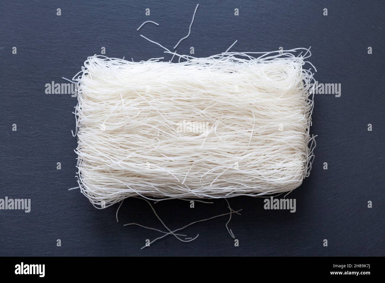 Vassoio per ardesia con al centro una pila di spaghetti di riso. Foto Stock
