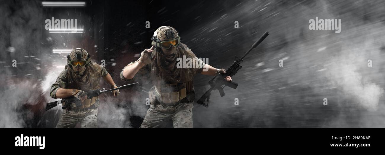 Durante un'operazione speciale, i soldati delle forze speciali professionali sono avvolti in fumo sullo sfondo di un muro di cemento scuro - sono Foto Stock