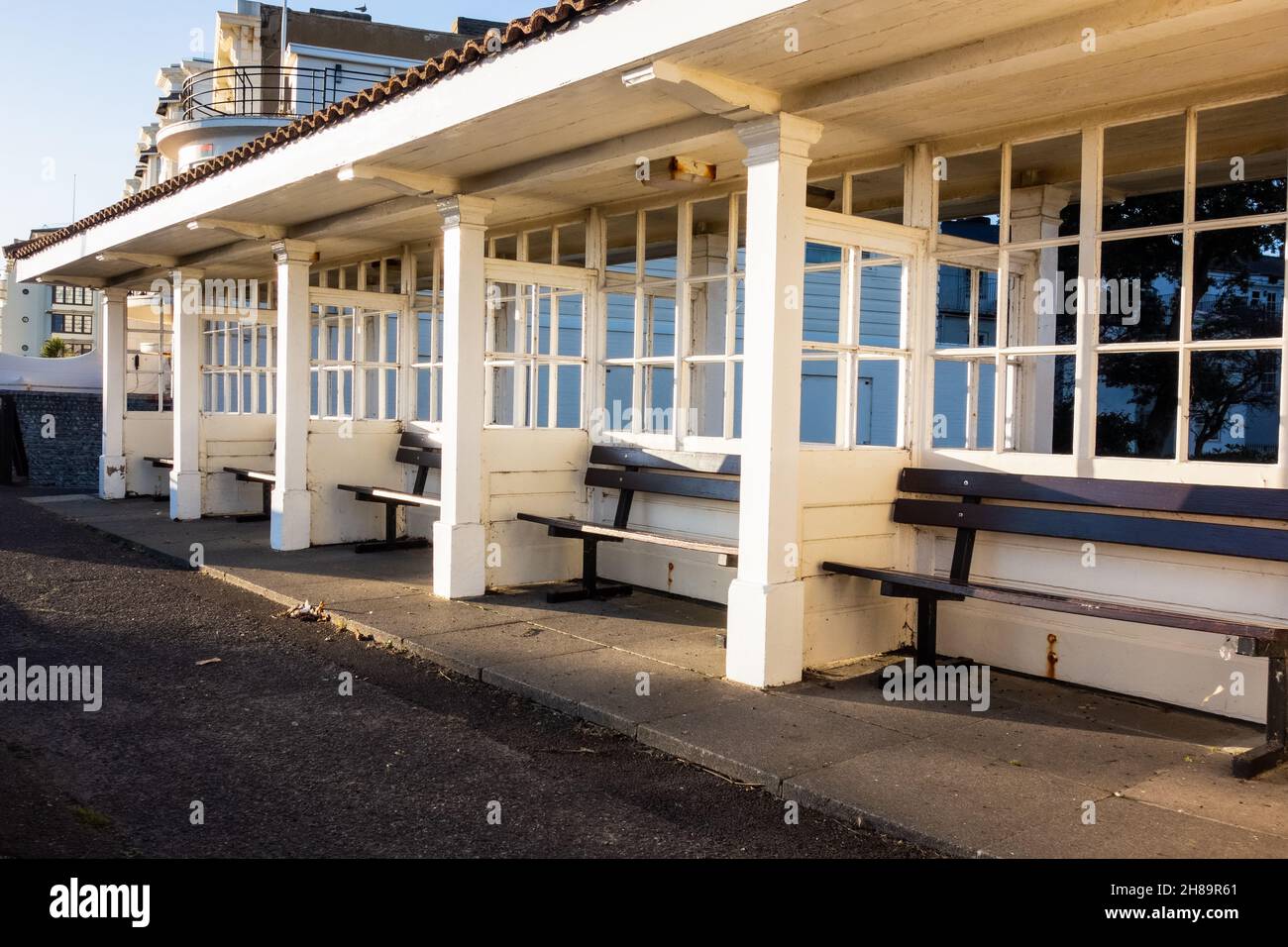 Una fila di posti a sedere vuoti all'interno di rifugi in legno sul lungomare di Worthing West Sussex Inghilterra, preso il 25 novembre 2021 Foto Stock