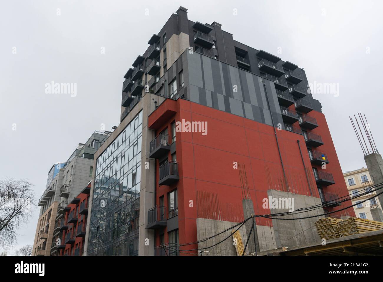 Costruzione di un edificio residenziale rosso a più piani. Strutture e raccordi in calcestruzzo. Foto Stock