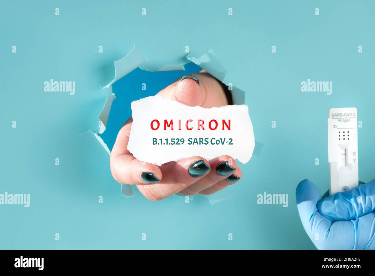 Omicron, nuova variante di preoccupazione del virus corona. Foro di carta con mano umana che mostra scarti di carta con nome della nuova variante. Mano nel guanto medico Foto Stock