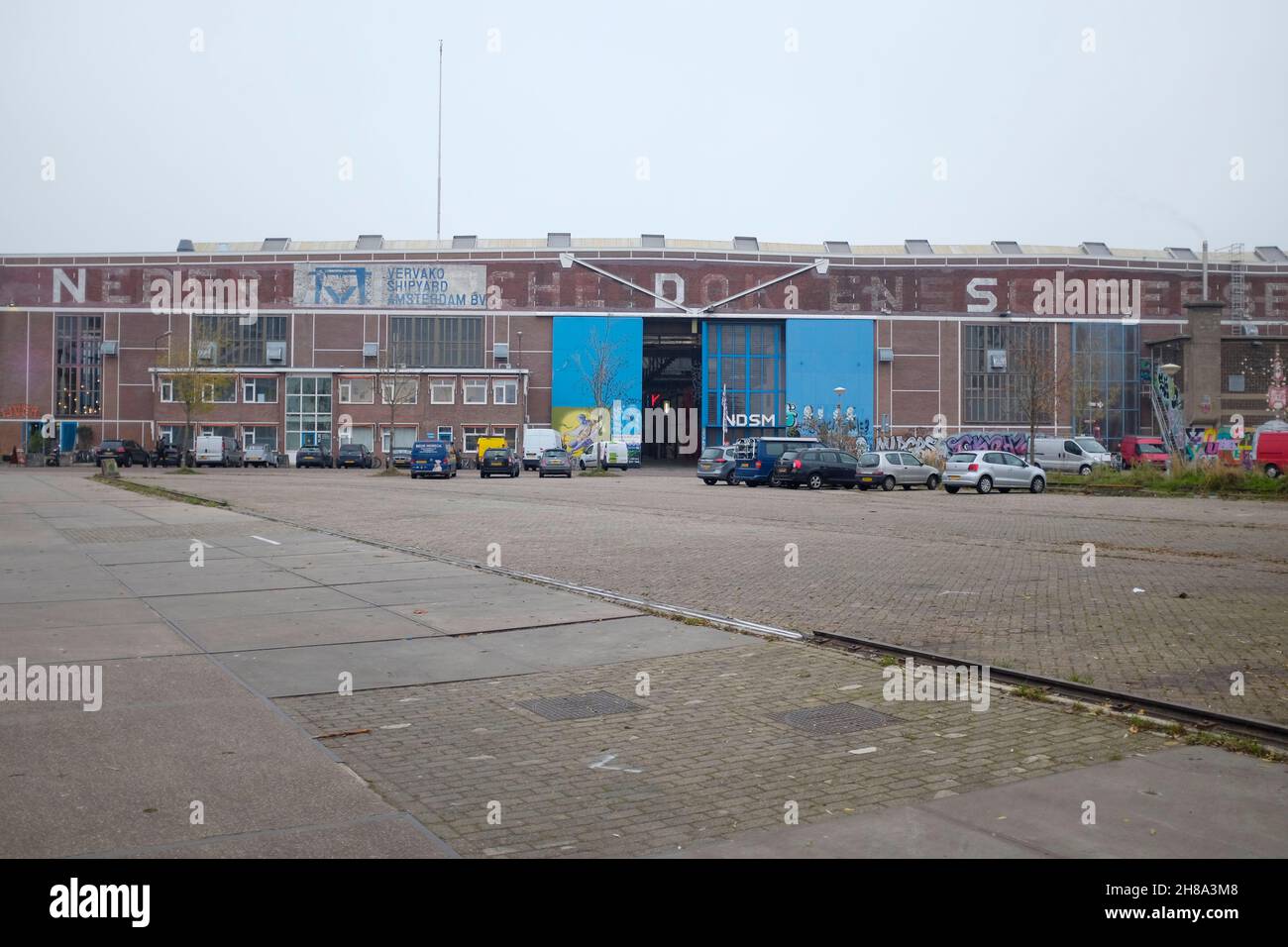 NDSM Amsterdam Street scene - una ex zona di banchina nel nord-ovest di Amsterdam che è utilizzato come spazio per artisti, mostre e festival. Foto Stock