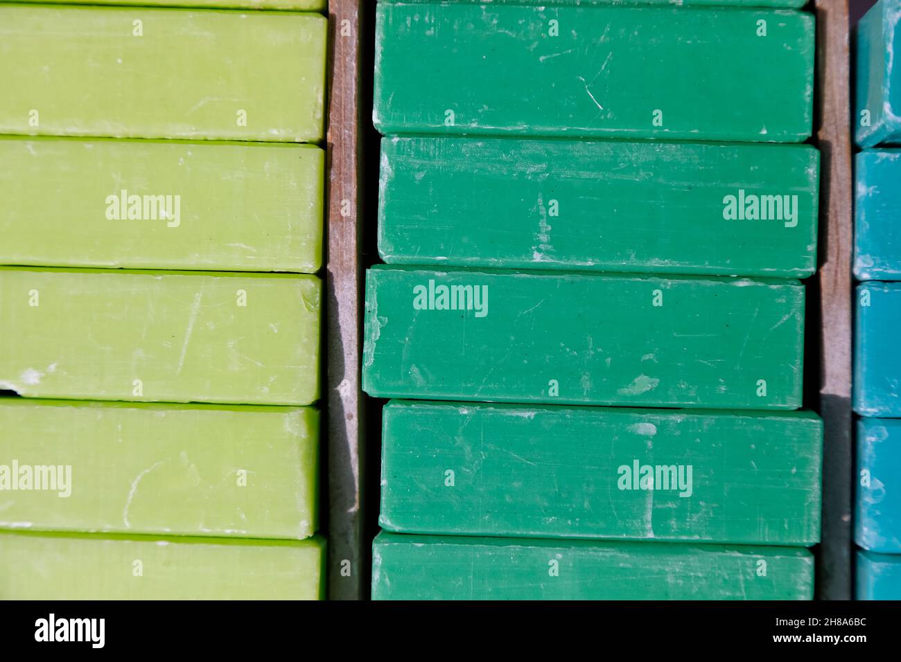 Cubi di sapone di colori e fragranze differenti disposti uno sopra l'altro e in pile uno accanto all'altro. Foto Stock