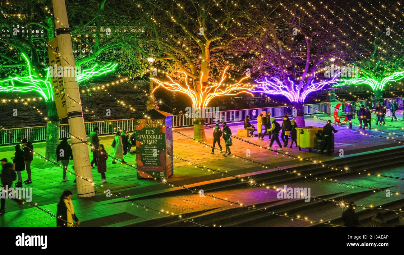 Londra, Regno Unito. 28 novembre 2021. I londinesi si siedono e passeggano lungo i canopie di alberi illuminati al neon che fanno parte delle luci invernali di Southbank quest'anno. Lo spettacolo gratuito può essere visto tutti i giorni dal tramonto fino alle 23.30, fino al 9 gennaio 2022. Credit: Imagplotter/Alamy Live News Foto Stock