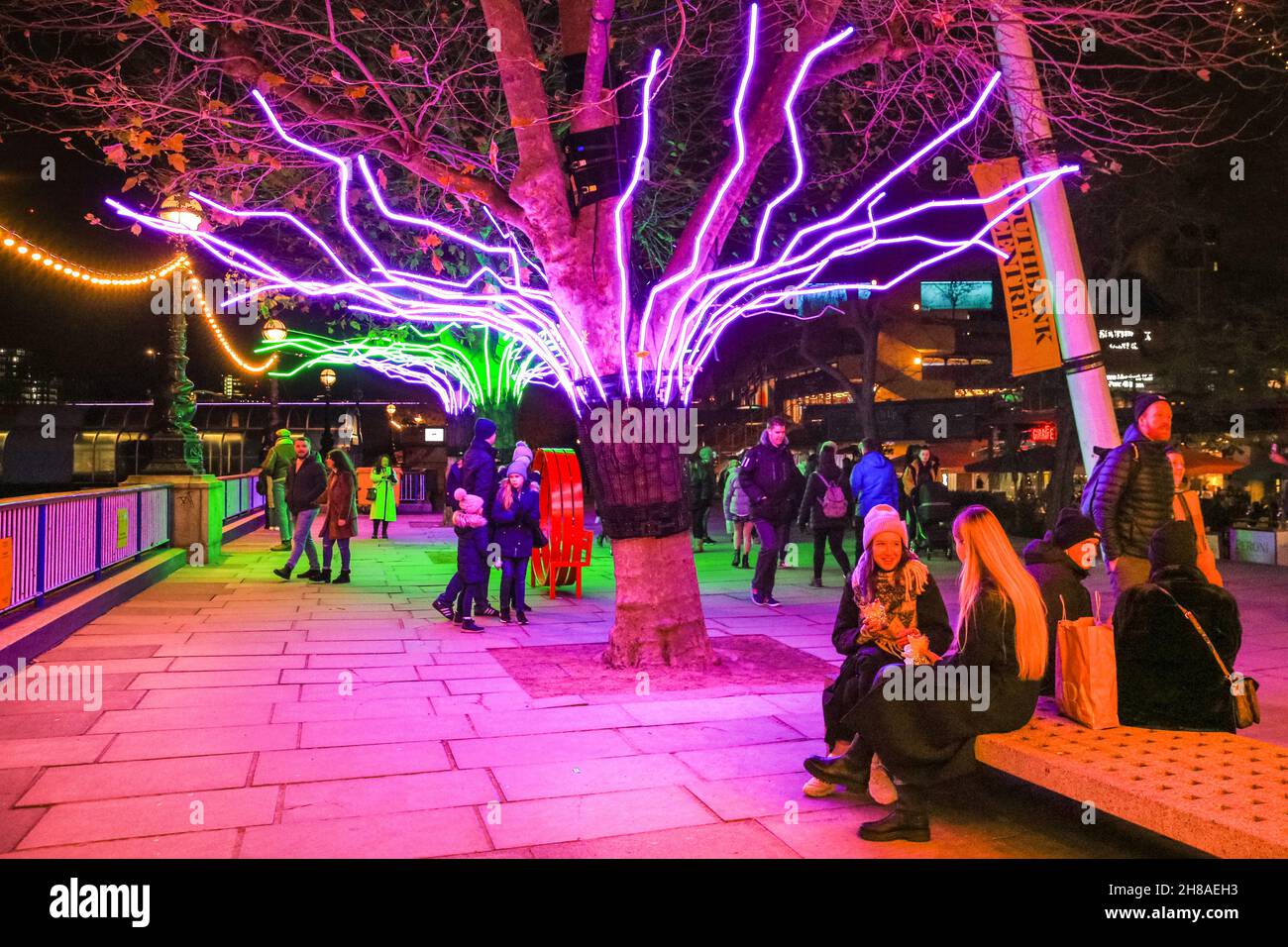 Londra, Regno Unito. 28 novembre 2021. I londinesi si siedono e passeggano lungo i canopie di alberi illuminati al neon che fanno parte delle luci invernali di Southbank quest'anno. Lo spettacolo gratuito può essere visto tutti i giorni dal tramonto fino alle 23.30, fino al 9 gennaio 2022. Credit: Imagplotter/Alamy Live News Foto Stock