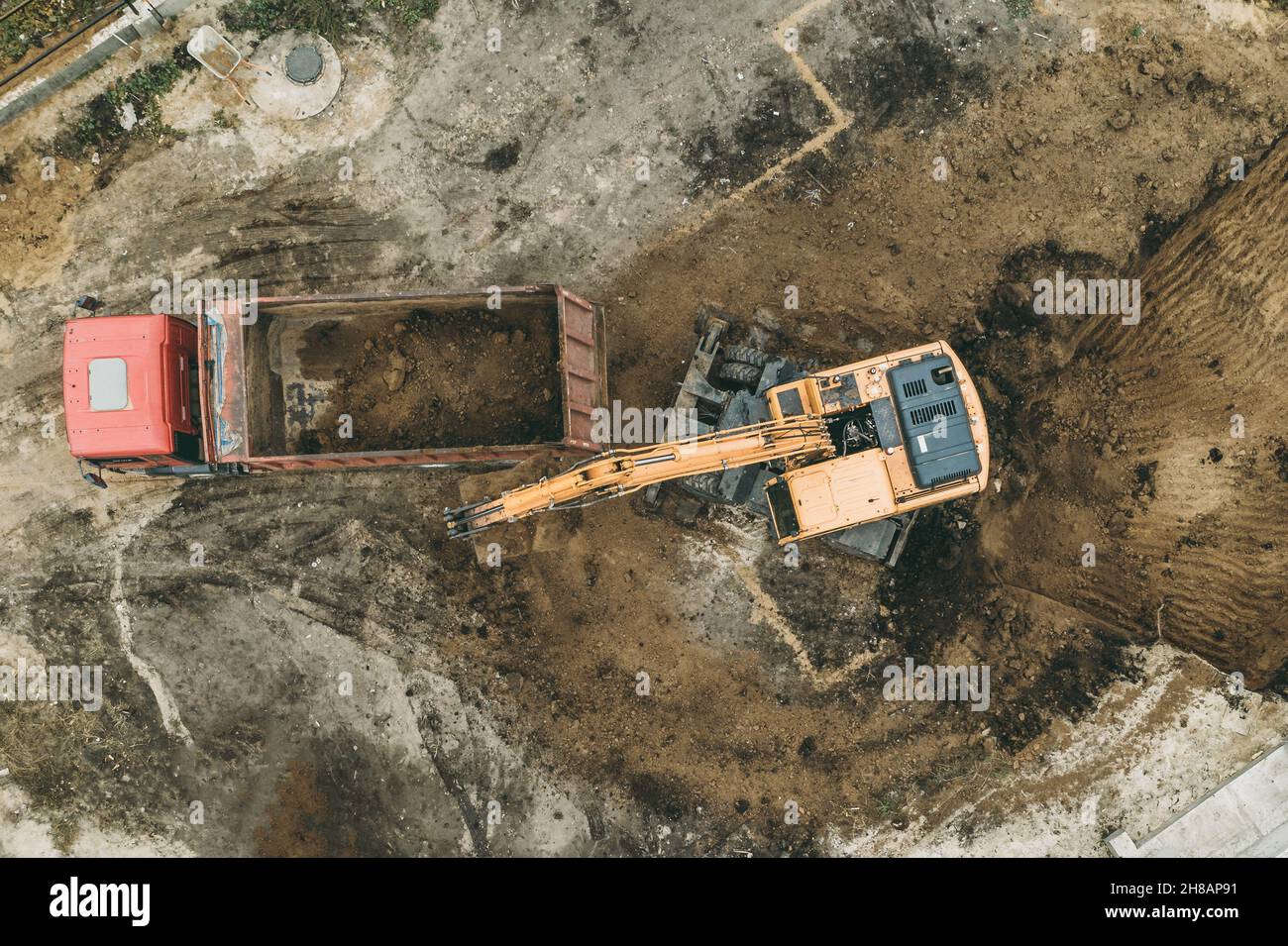 Scavatore scava pozzo fondazione. Lavori di scavo in cantiere, vista dall'alto aerea. Foto Stock
