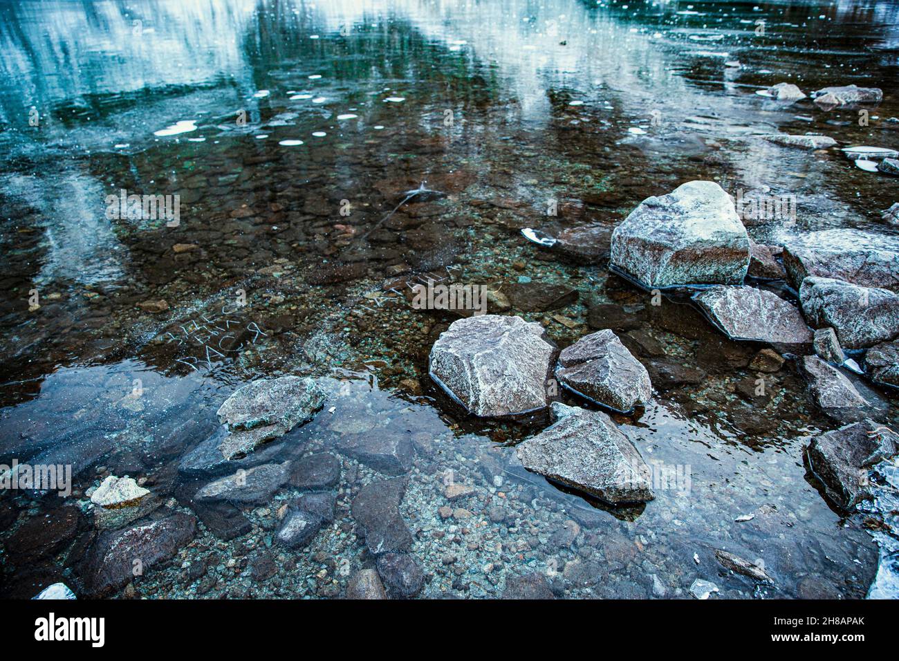 Acque ghiacciate di lago verde e pietre, da vicino. Foto Stock