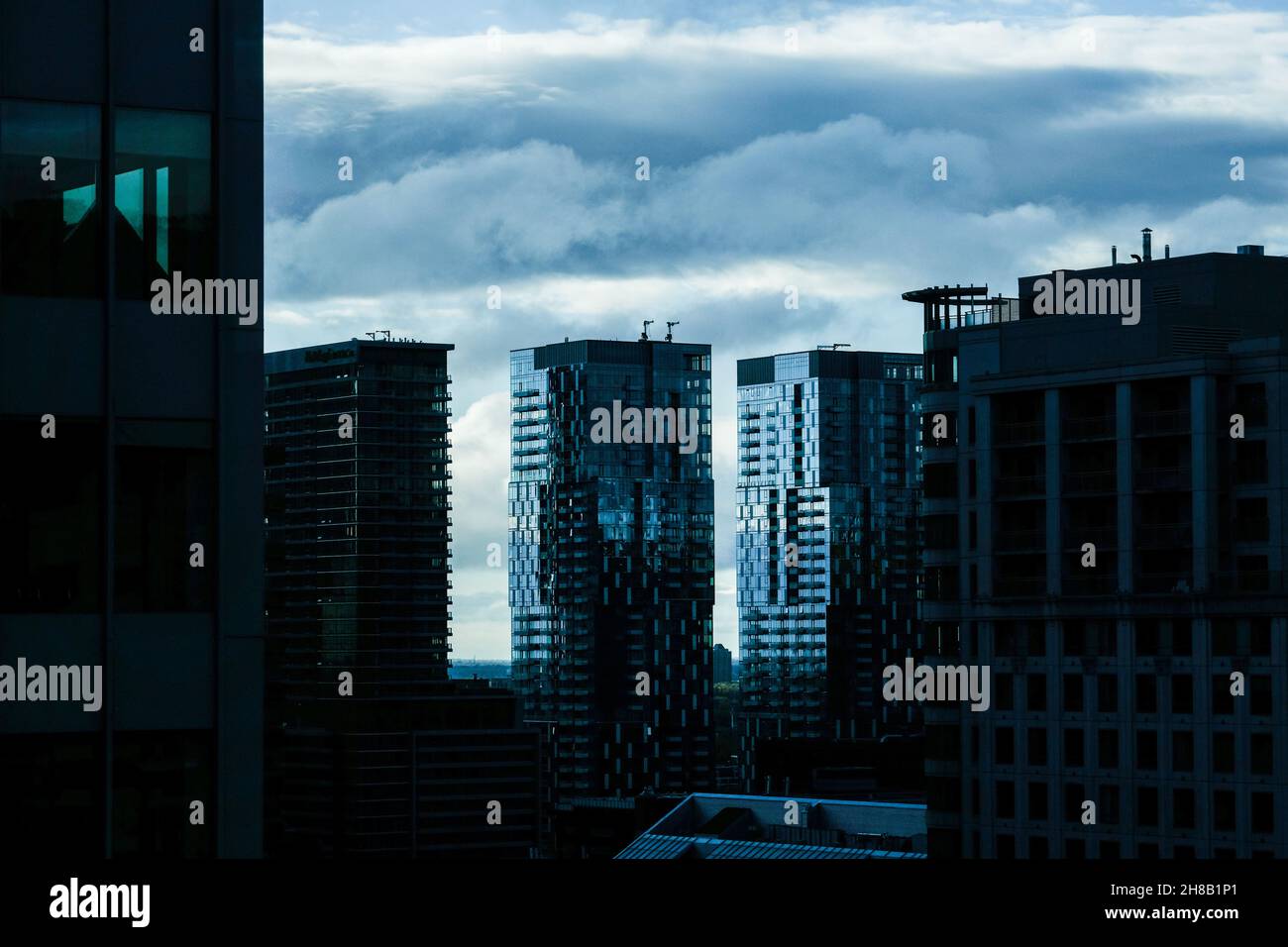 Moody cieli e silhouette di edifici urbani a Montreal, Quebec, Canada, vista dalla sezione Golden Square Mile della città. Foto Stock