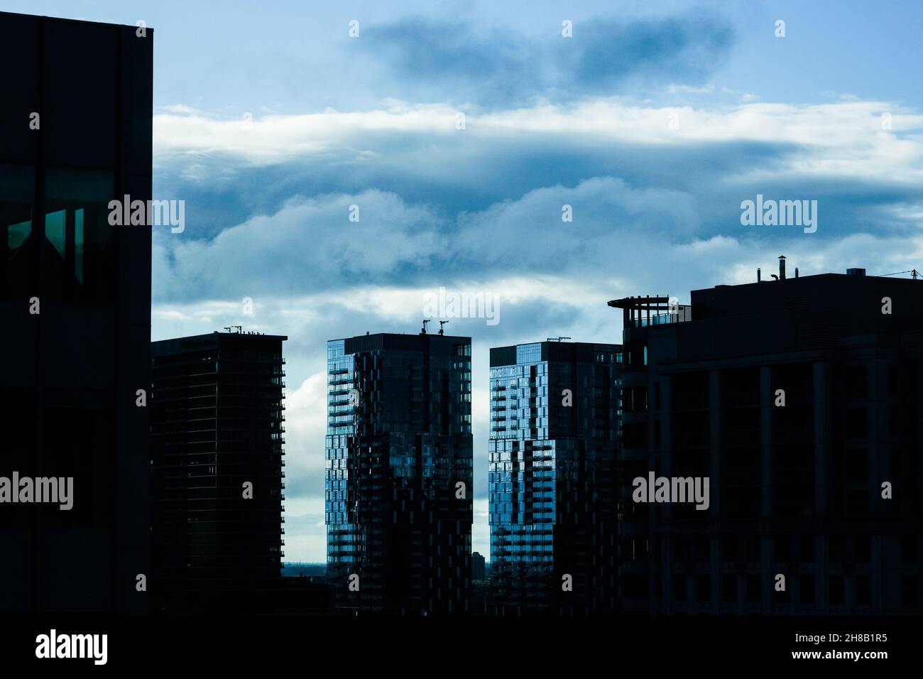 Moody cieli e silhouette di edifici urbani a Montreal, Quebec, Canada, vista dalla sezione Golden Square Mile della città. Foto Stock