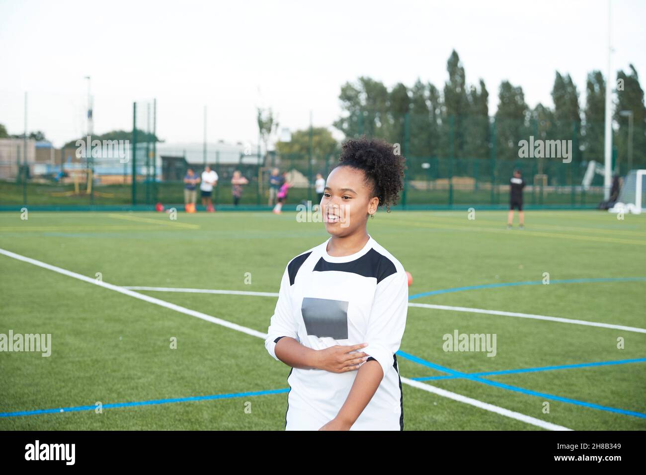 Regno Unito, giocatore di calcio femminile sorridente (12-13) in campo di calcio Foto Stock