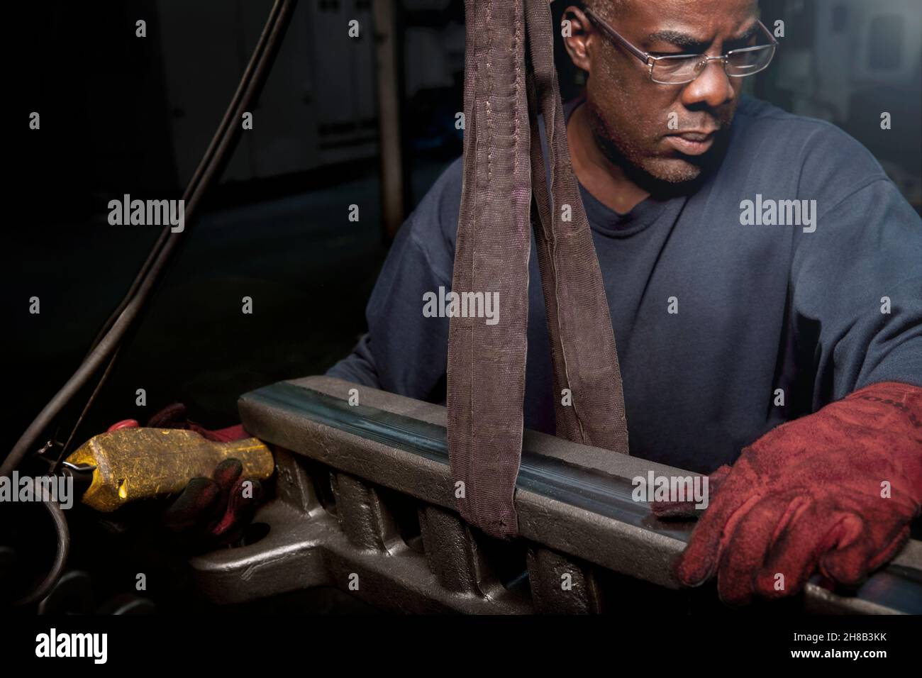 Il sollevamento di una barra a cremagliera per essere lavorata Foto Stock