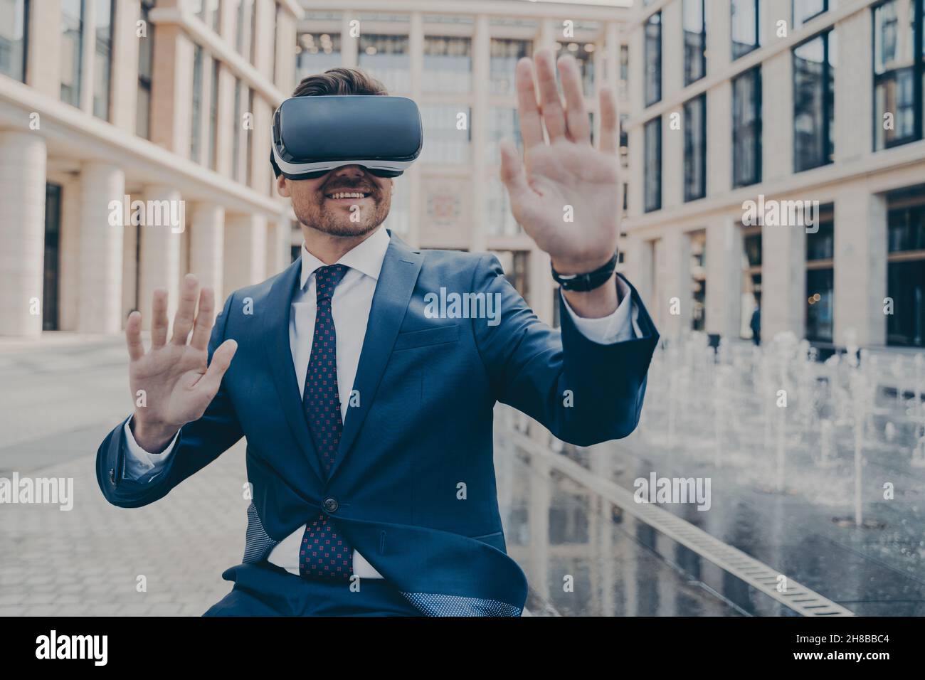 Il lavoratore d'ufficio entusiasta in tuta formale che controlla le informazioni in realtà virtuale Foto Stock