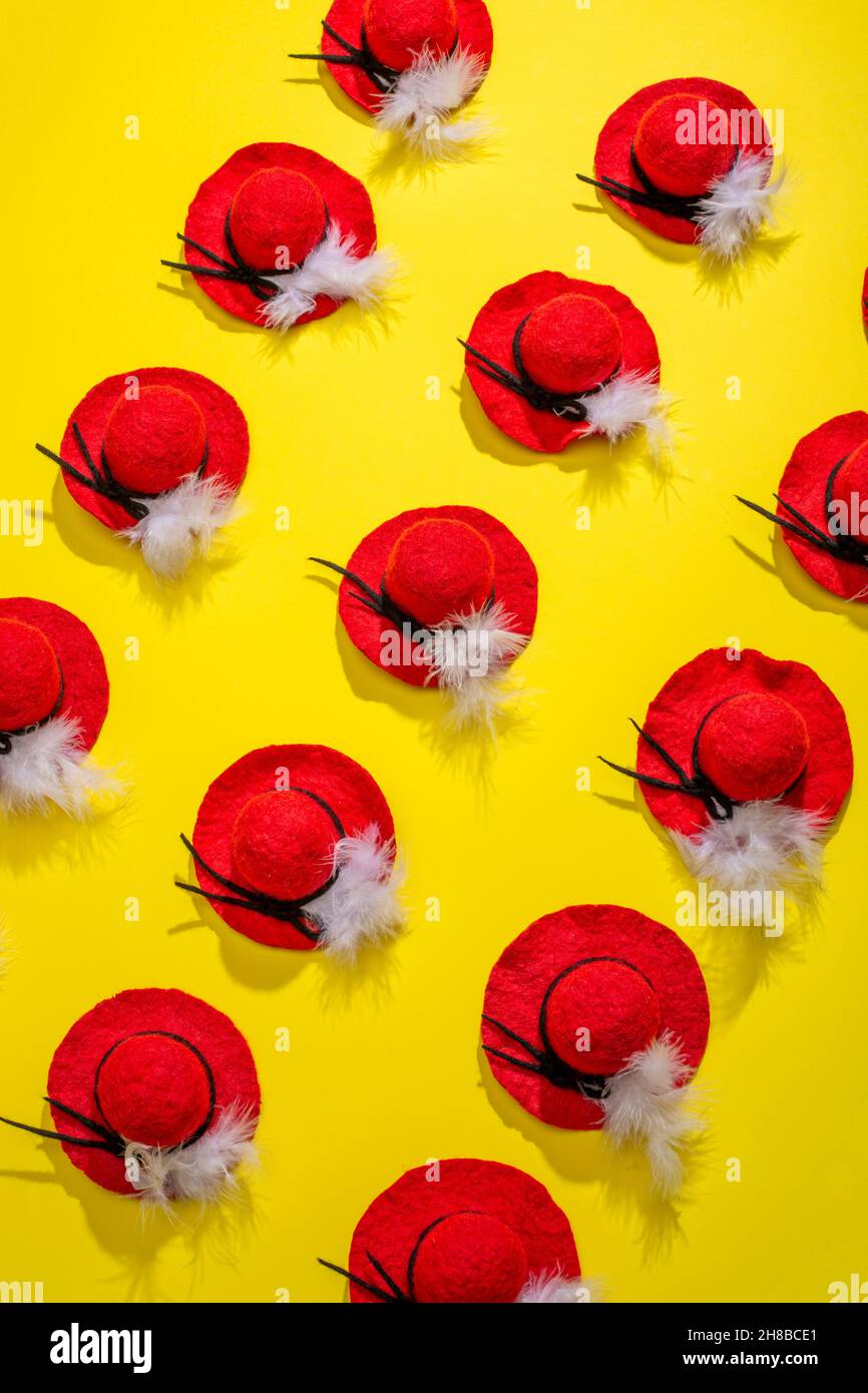 Quindici cappelli di lana feltrati con una piuma su sfondo giallo Foto Stock