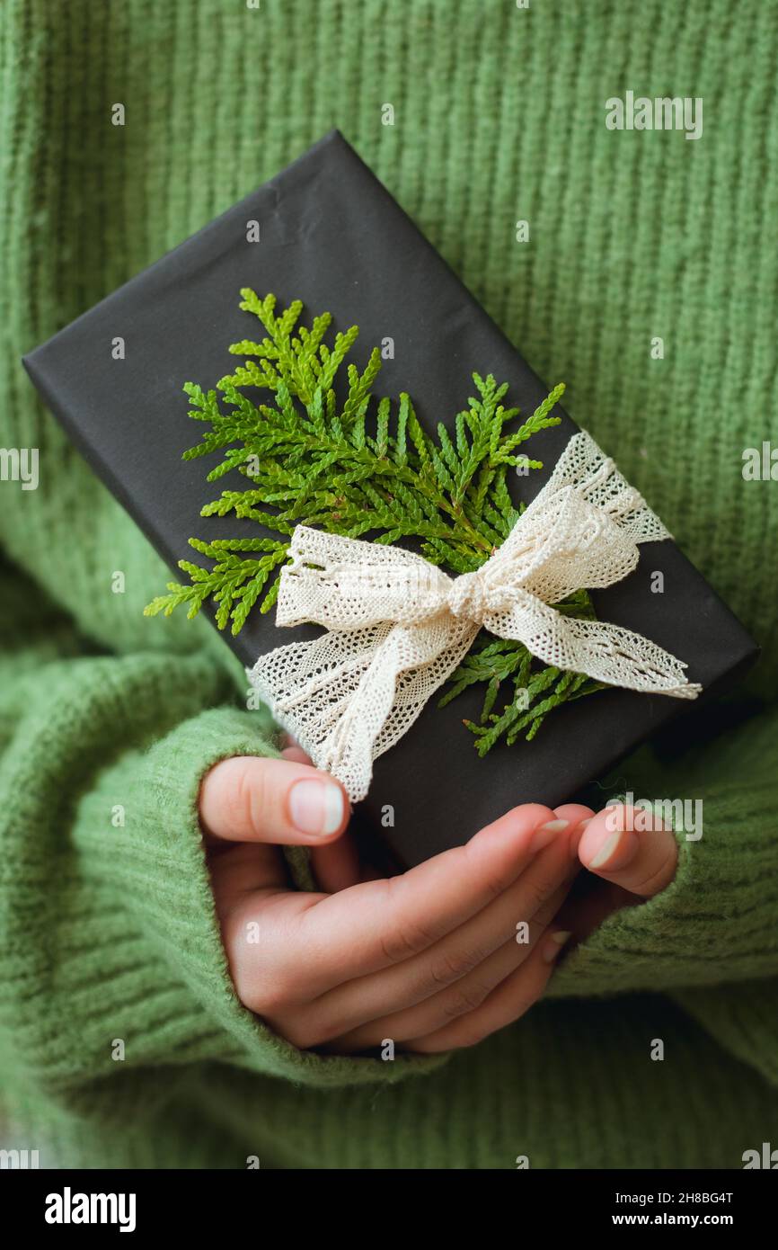 Accogliente regalo di Natale in mano della donna, primo piano Foto Stock