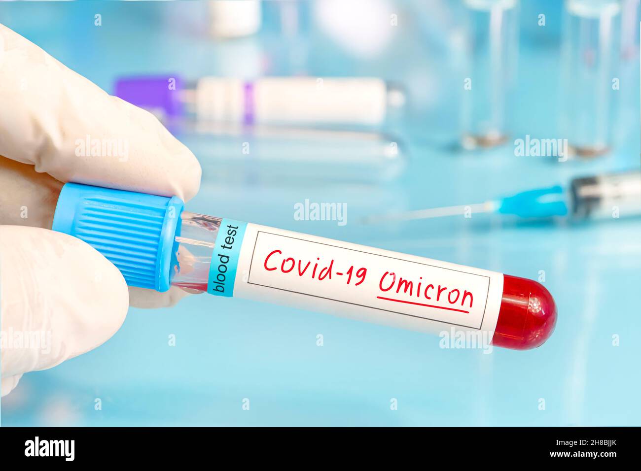Medico con campione di sangue positivo per la nuova variante rilevata del ceppo di coronavirus chiamato covid Omicron. Ricerca di nuovi ceppi e mut africani Foto Stock