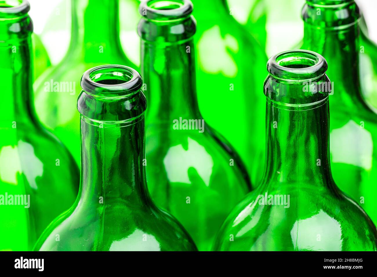 Molte bottiglie verdi in una fila Foto Stock