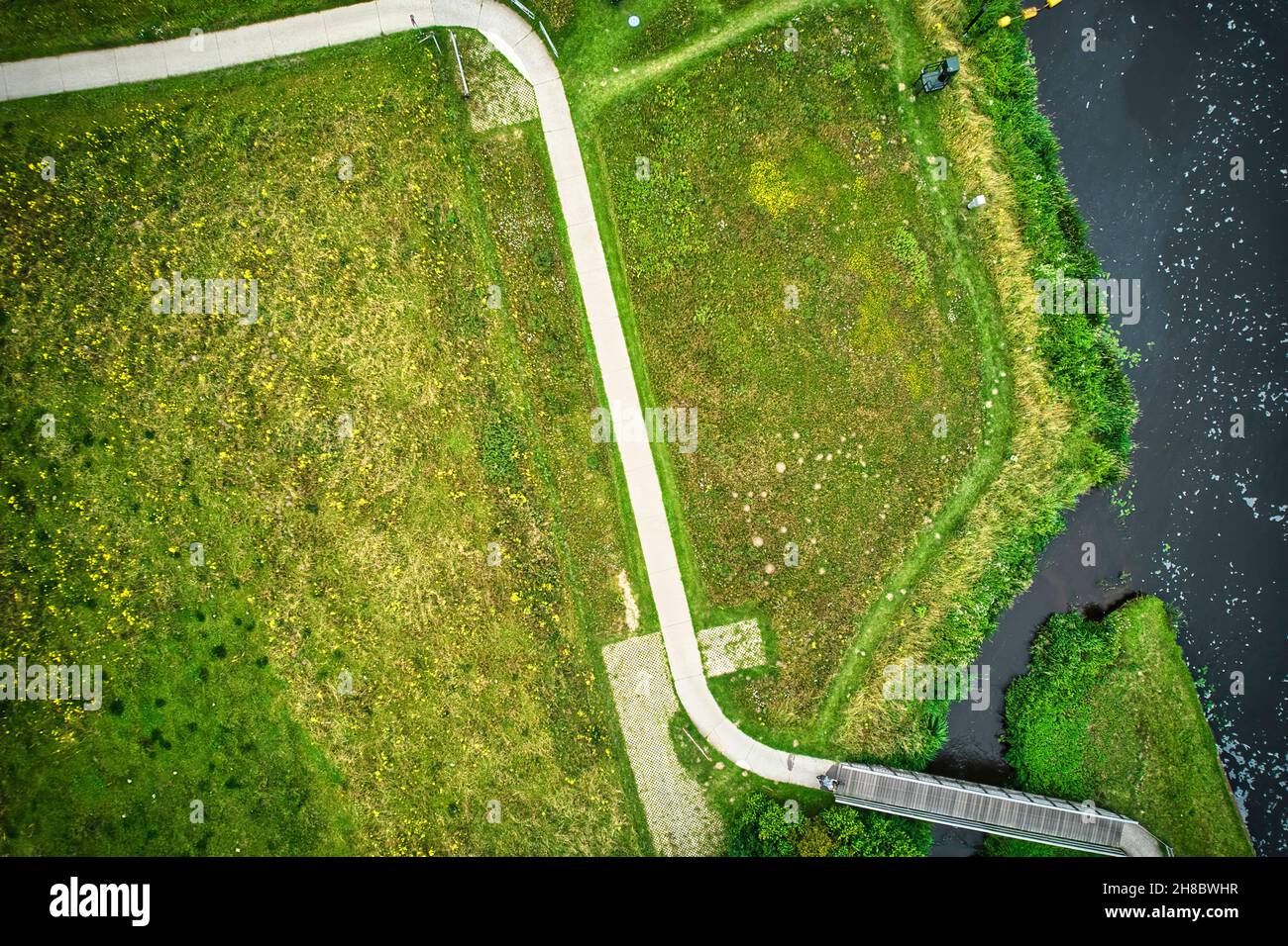 Drone uitzicht op de rivier de Vecht, gras gras gras gras, acqua blauw, stad met hoogspanningspalen. Een fietser op het fietspad bij de brug. Vechtdal, Dalfsen Foto Stock