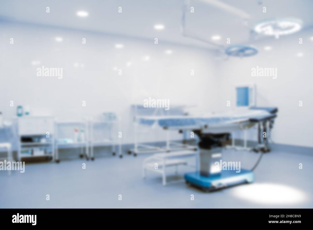 Foto sfocata della sala operatoria in ospedale. Apparecchiatura chirurgica con tavolo operatorio. Dispositivo medico per pazienti di emergenza in stile blu Foto Stock