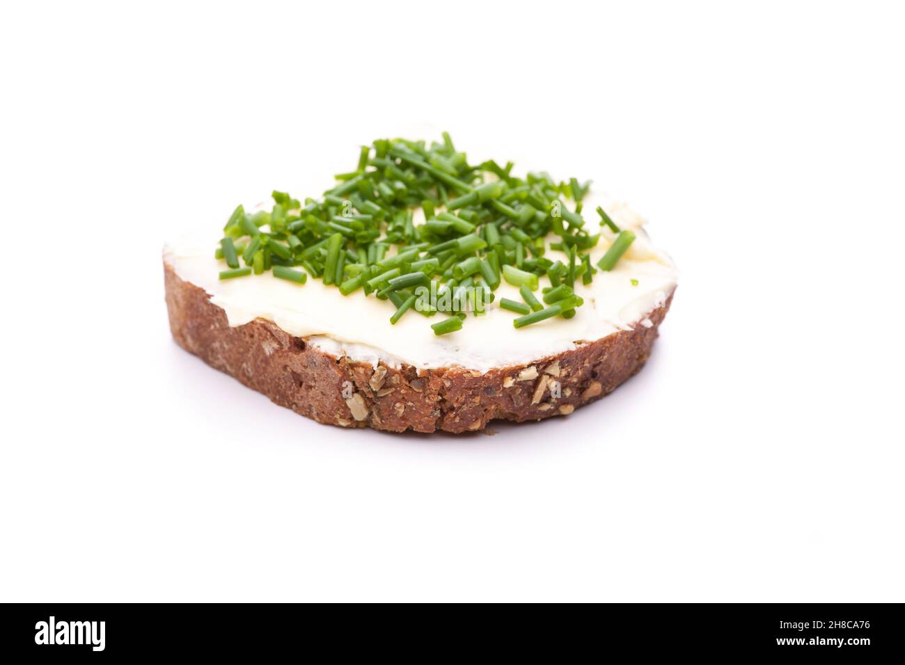 Burro pane con erba cipollina isolato su sfondo bianco Foto Stock