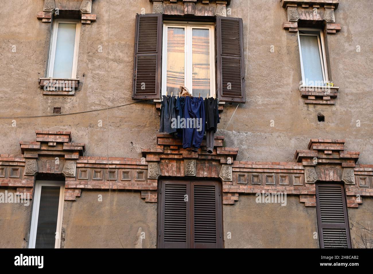 Una tipica vecchia casa italiana con una linea di vestiatura tra le finestre. Foto Stock
