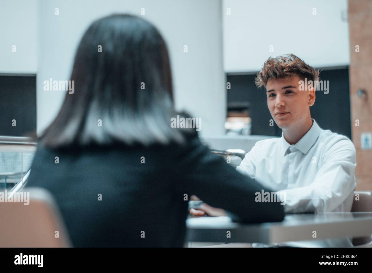 Un manager che lavora duramente chiacchierando in squadra con il suo cliente nel suo ufficio in una riunione seduta Foto Stock