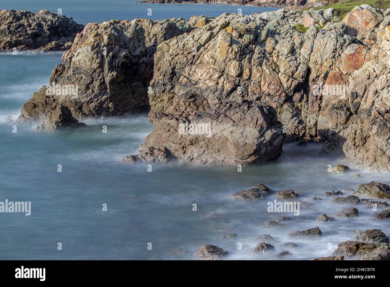 La penisola di Howth Head in giornata soleggiata e nuvolosa, esposizione a lungo, Dublino County, Seashore di scogliere, baie e rocce paesaggio, Irlanda Foto Stock