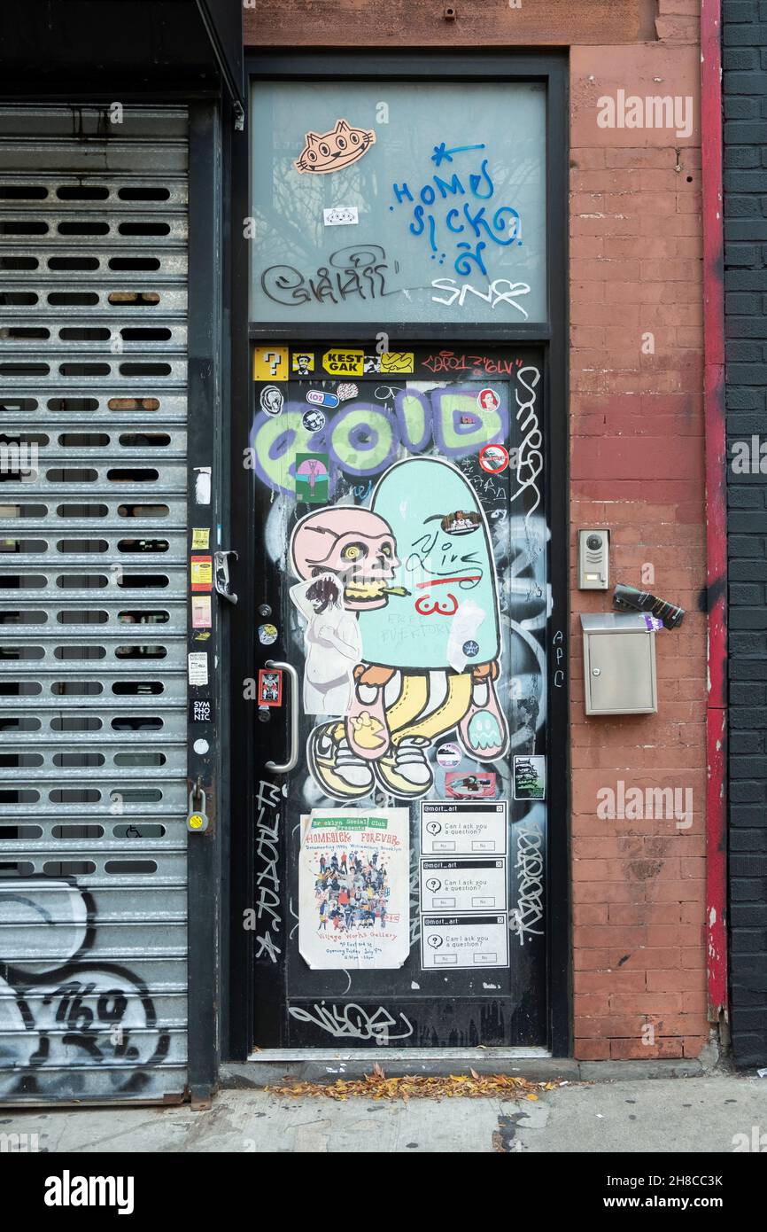 Una porta completamente coperta di adesivi, Street art, graffiti e tag. Su Bedford Ave. A Williamsburg, Brooklyn, New York. Foto Stock
