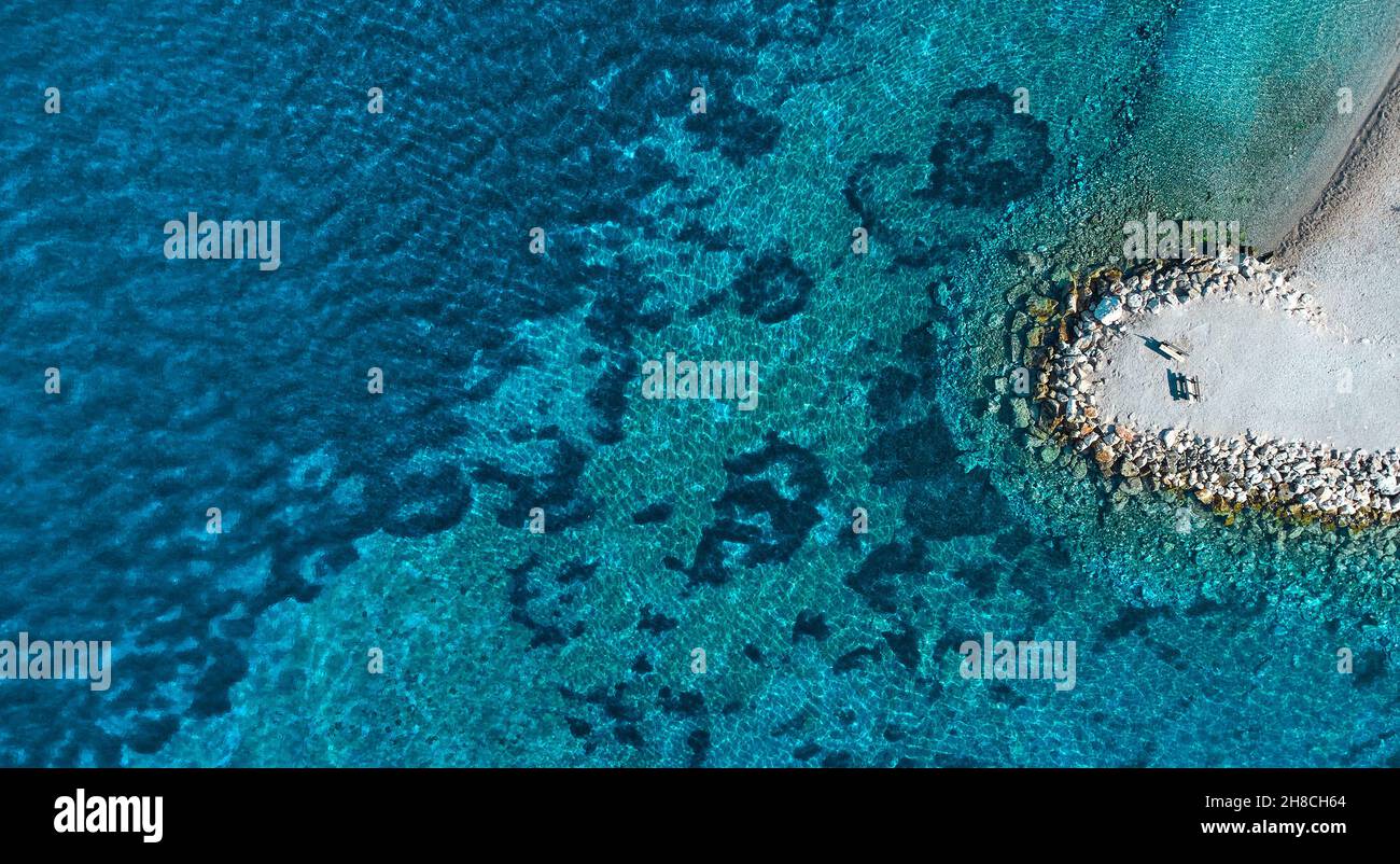 Vista aerea della costa. Il mare turchese azzurro confina con una costa di pietra. Spazio di copia Foto Stock