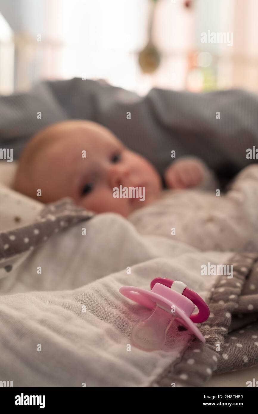 bambina con un succhietto sul letto al mprning Foto Stock