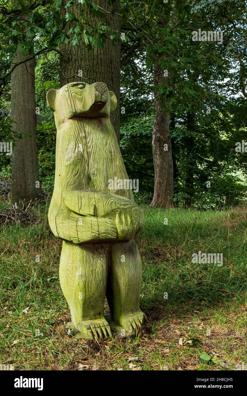 Orso di legno che tiene un pesce, scultura sul sentiero di scultura Allen Coppice, LongMynd House, Church Stretton, Shropshire, Inghilterra Foto Stock