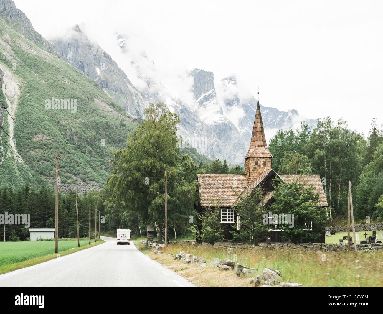 Vista della strada, chiesa e montagne in Norvegia. Concetto di viaggio in auto Foto Stock