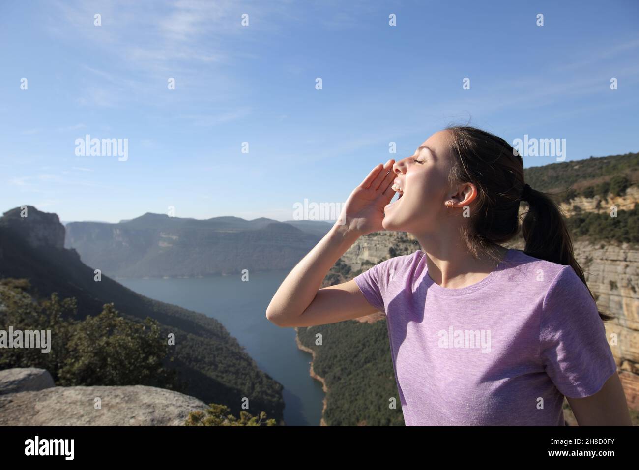 Ritratto della vista laterale di una donna che gridava forte in montagna Foto Stock