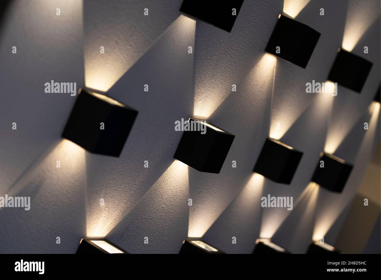 lampade quadrate nere su una parete beige, il gioco di luce e ombra bellissimo design d'interni e l'illuminazione di interni ed esterni decorazione. Foto Stock