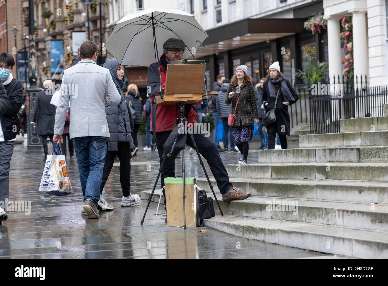 Street artist si è levato in piedi a easel, St Martin's Lane, London's West End, Inghilterra, Regno Unito Foto Stock