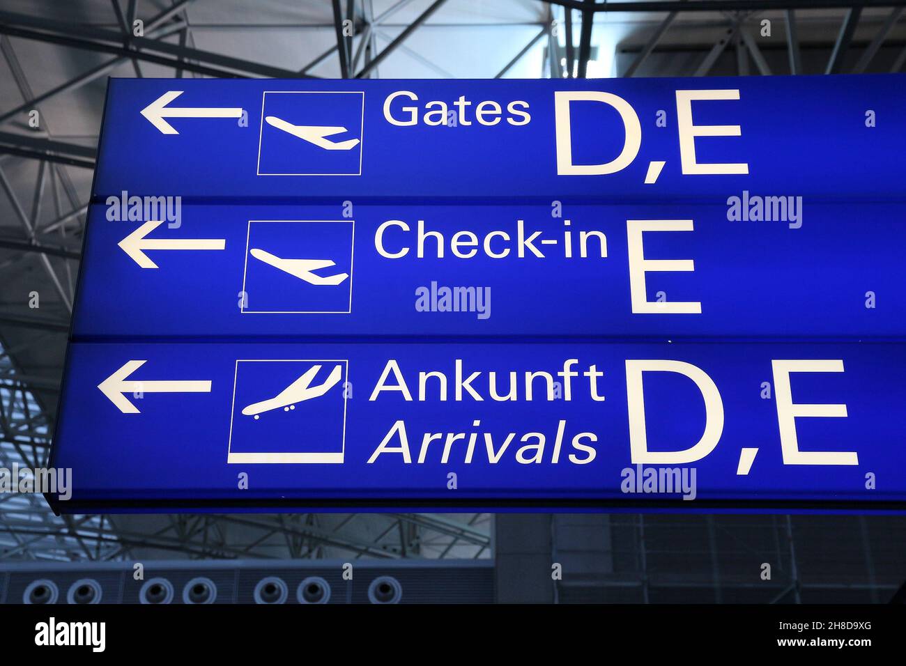 Segnaletica generica per l'aeroporto di Francoforte. Cancelli illuminati, cartello per il check-in e gli arrivi (in lingua inglese e tedesca). Foto Stock