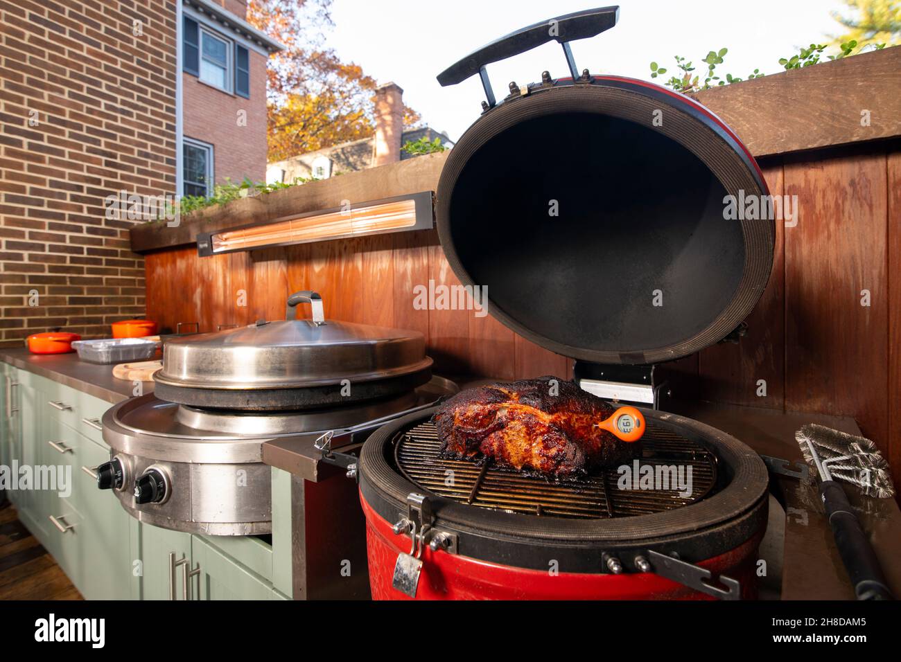 Cucina esterna fumatore e grill piano cottura di un culo di maiale o spalla utilizzando un termometro a carne per controllare la temperatura interna Foto Stock
