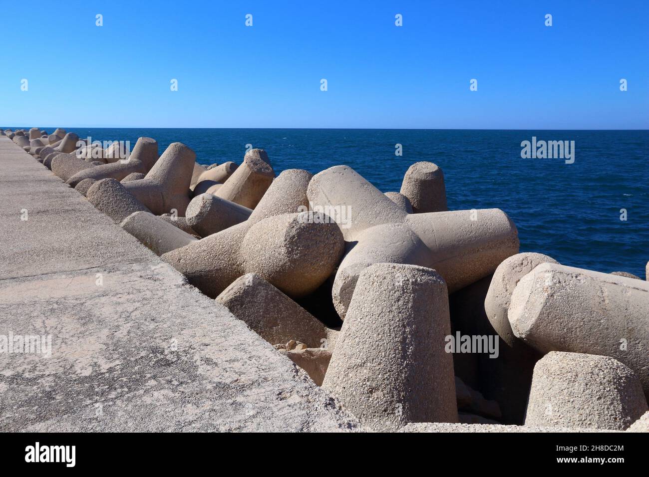 Tetrapodi di frangiflutti in calcestruzzo e Mare Adriatico a Giovinazzo, Italia. Foto Stock