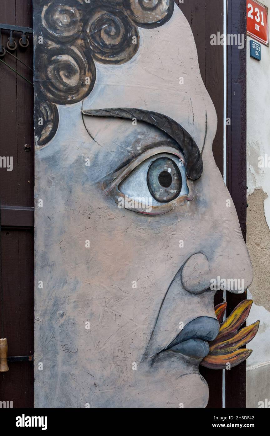 Il volto di un uomo si affaccia dall'otturatore dell'Obchod loutkami (negozio di marionette) in via Nerudova, nella Malá Strana di Praga Foto Stock