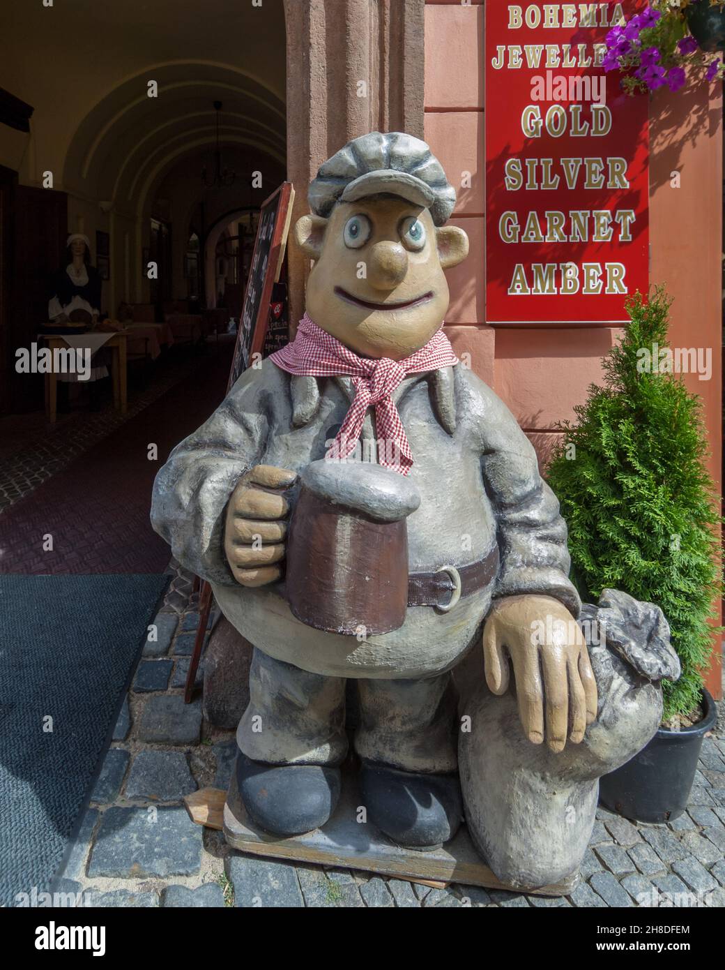 Un burgher allegro, con un drink in mano, saluta i visitatori del tradizionale ristorante ceco U Mlynáře in via Nerudova Foto Stock