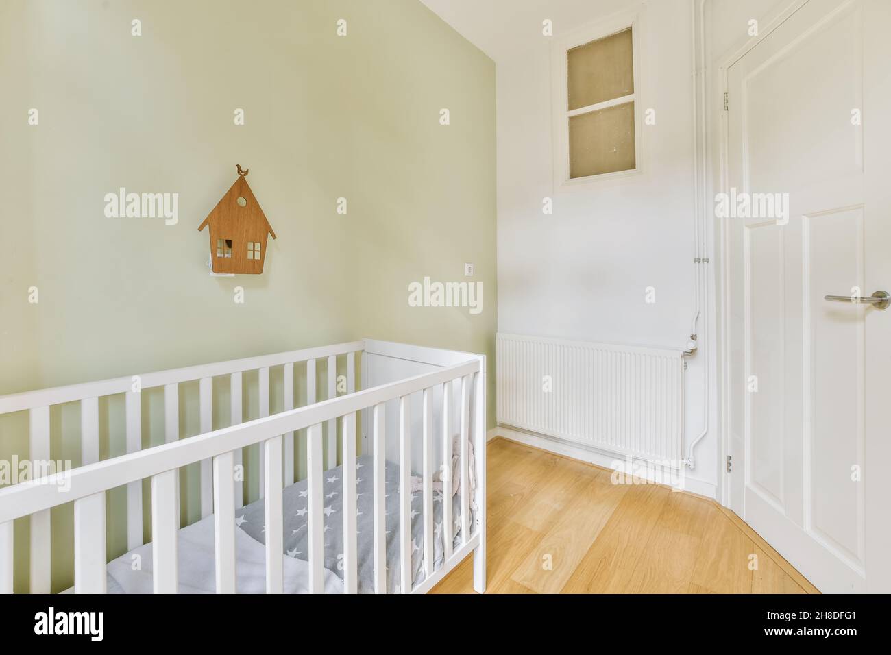 Camera per bambini deliziosa e luminosa con una piccola culla Foto Stock