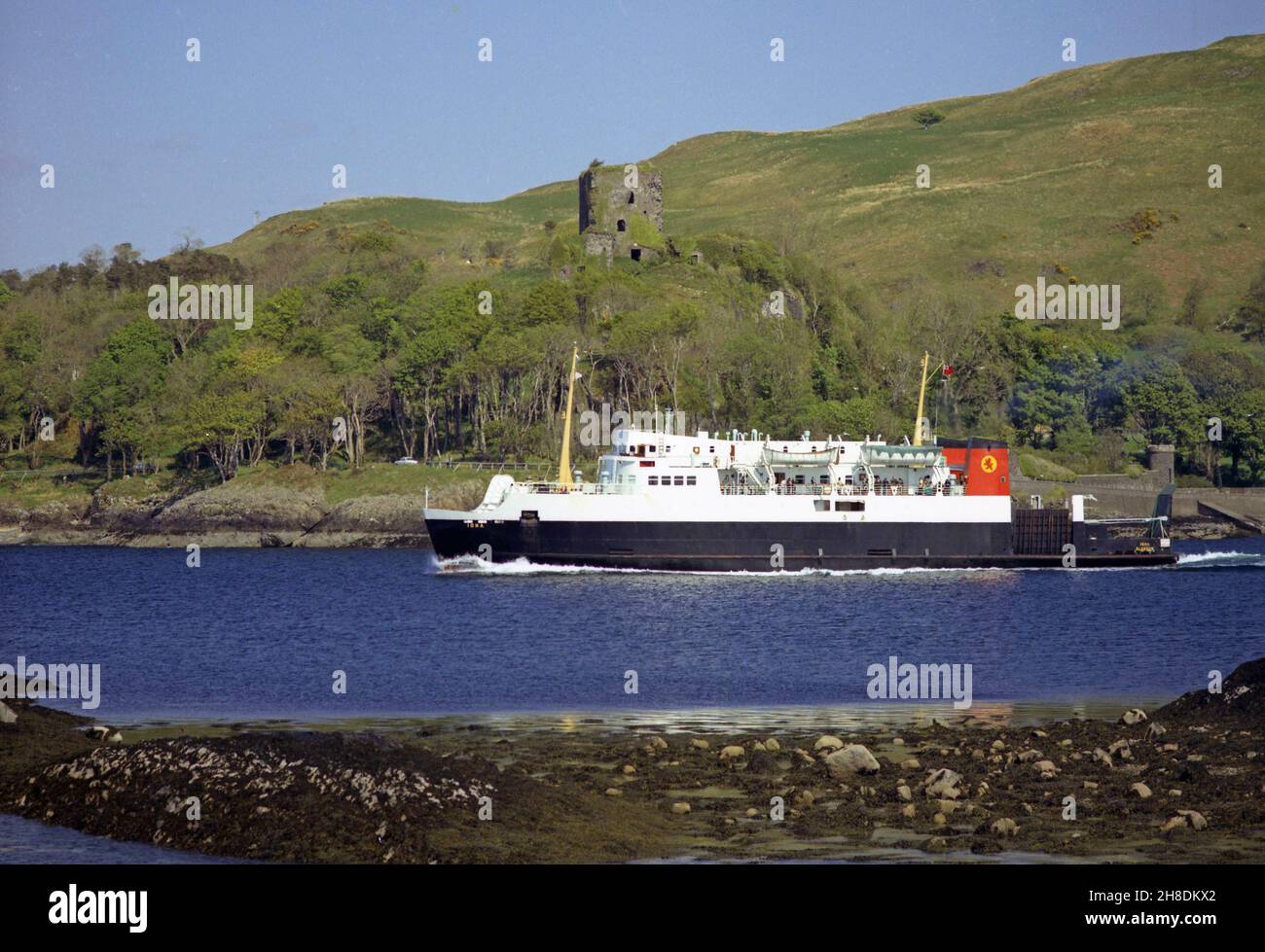 La MV Iona supera il castello di Dunollie mentre esce dalla baia di Oban degli anni '70 Foto Stock