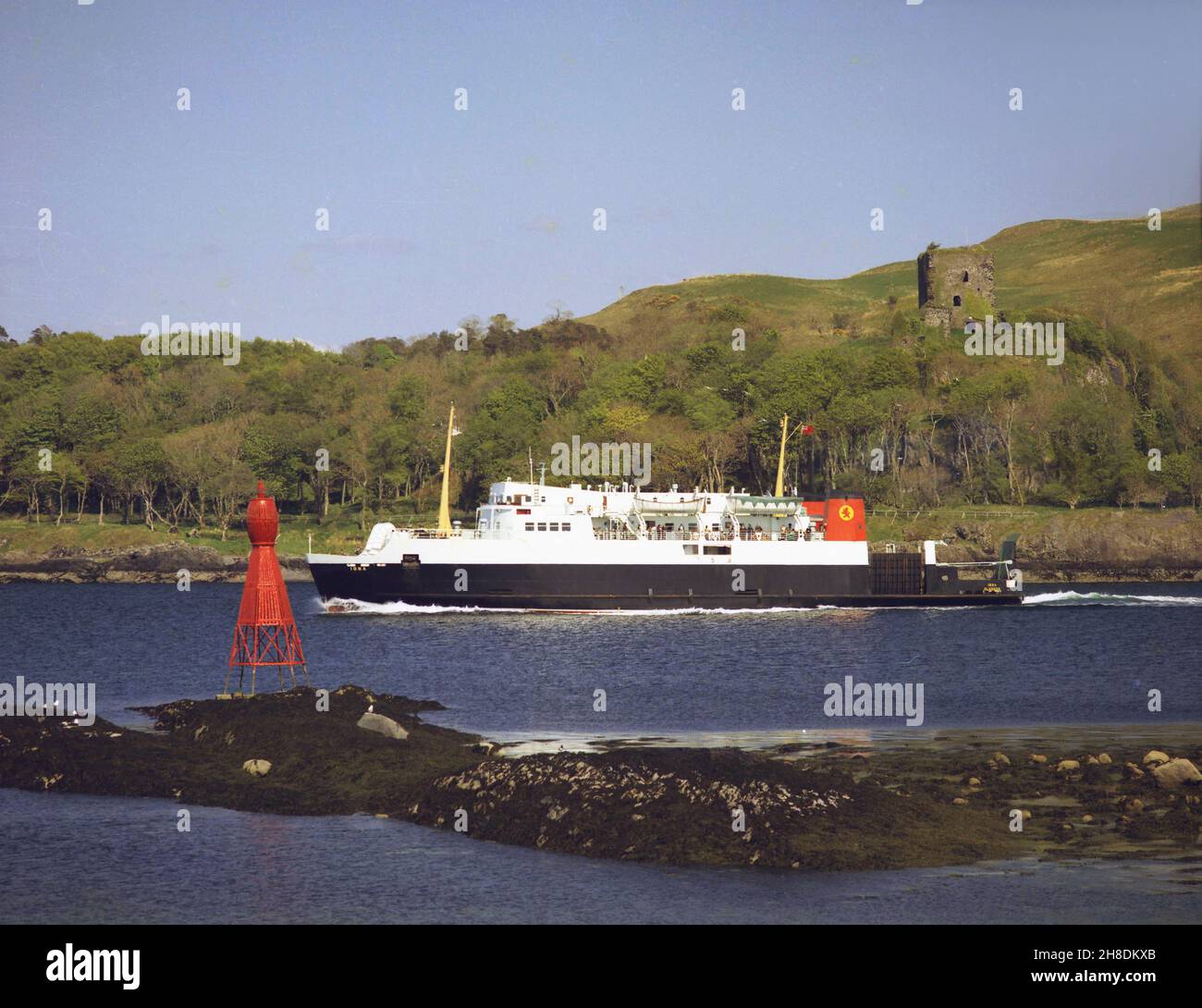 La MV Iona supera il castello di Dunollie mentre esce dalla baia di Oban degli anni '70 Foto Stock