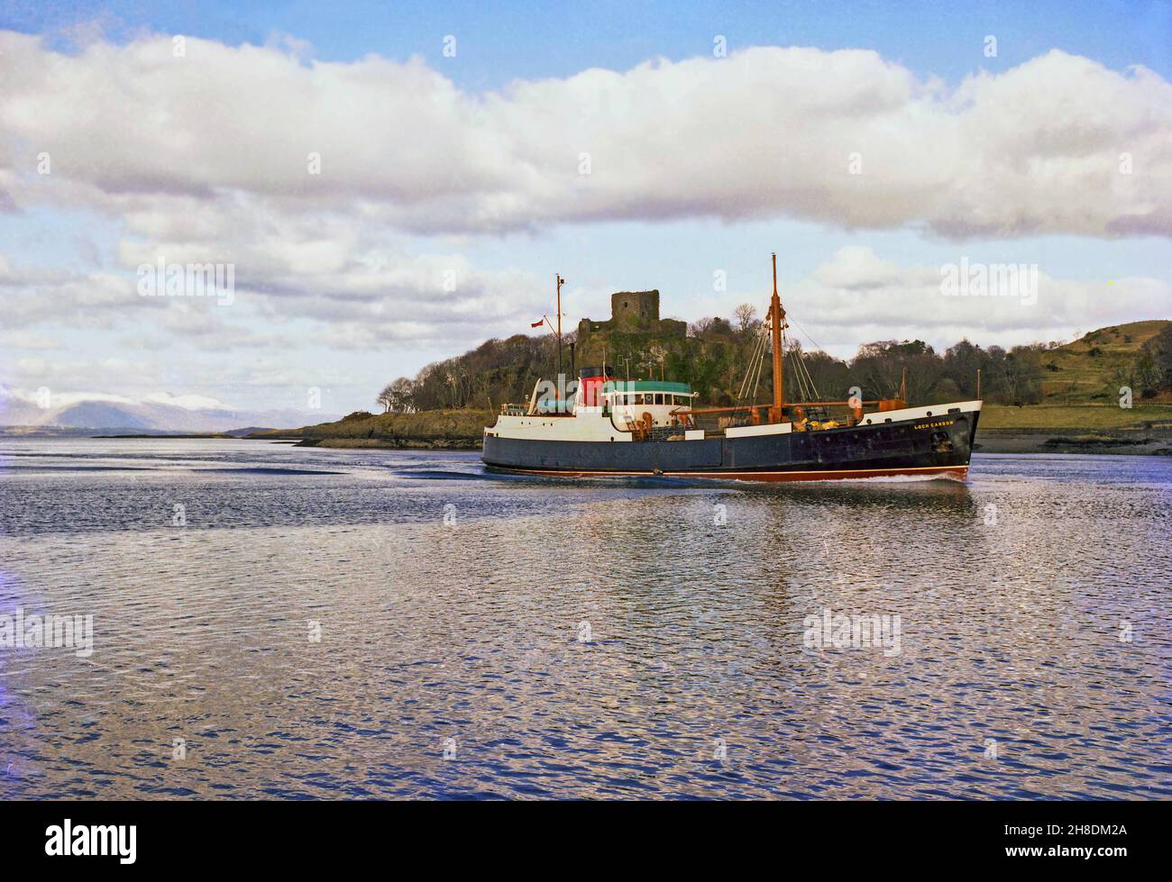 MV Loch Carron entra nella baia di Oban degli anni '70 con il castello di Dunollie in vista. Foto Stock