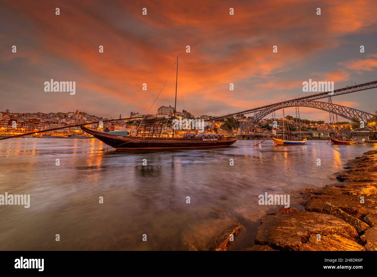 Vista sul Rio Douro al tramonto a Porto con le tradizionali imbarcazioni porta in primo piano. Foto Stock