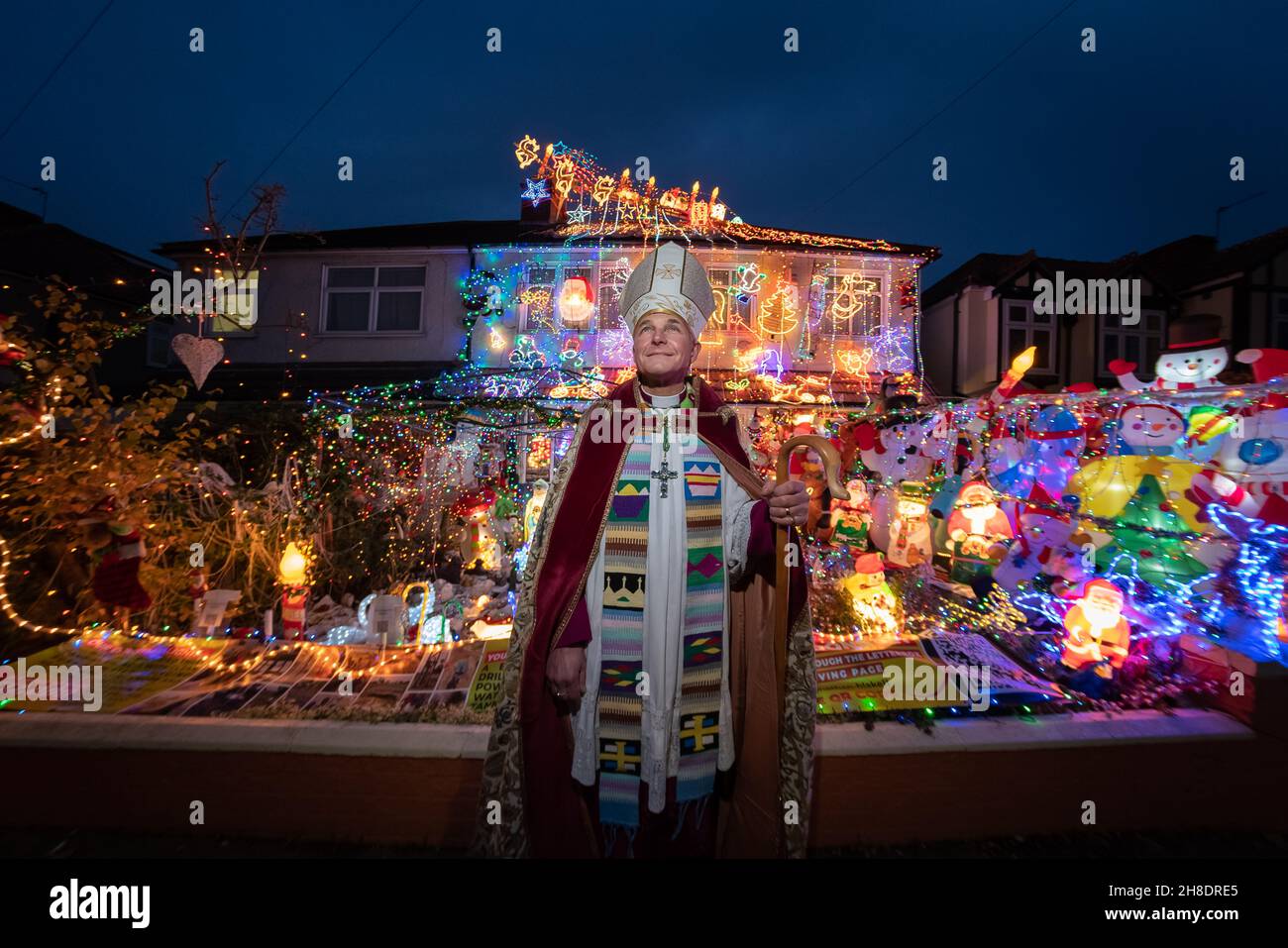 Londra, Regno Unito. 29 novembre 2021. Spettacolare mostra di luci della casa di Natale a Welling. Jonathan Blake (nella foto), Arcivescovo residente della Chiesa episcopale aperta, ha decorato la sua casa di famiglia ogni anno dal 2002. Per alcuni dei bambini locali, "la Casa di Natale" come la chiamano, è una parte vitale della loro esperienza di Natale. Bishop Blake utilizza il display annuale delle luci per aiutare a raccogliere fondi per fornire acqua pulita ai piccoli villaggi in Gambia. Credit: Guy Corbishley/Alamy Live News Foto Stock