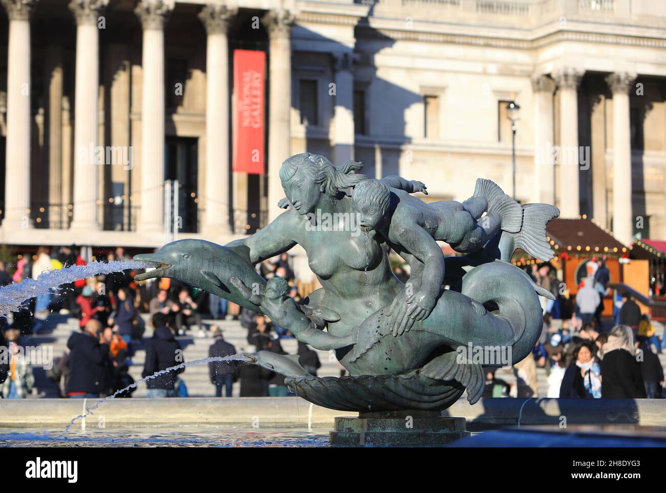 Le fontane su Trafalgar Square con il mercato di Natale fuori dalla National Gallery nel centro di Londra, 2021, Regno Unito Foto Stock