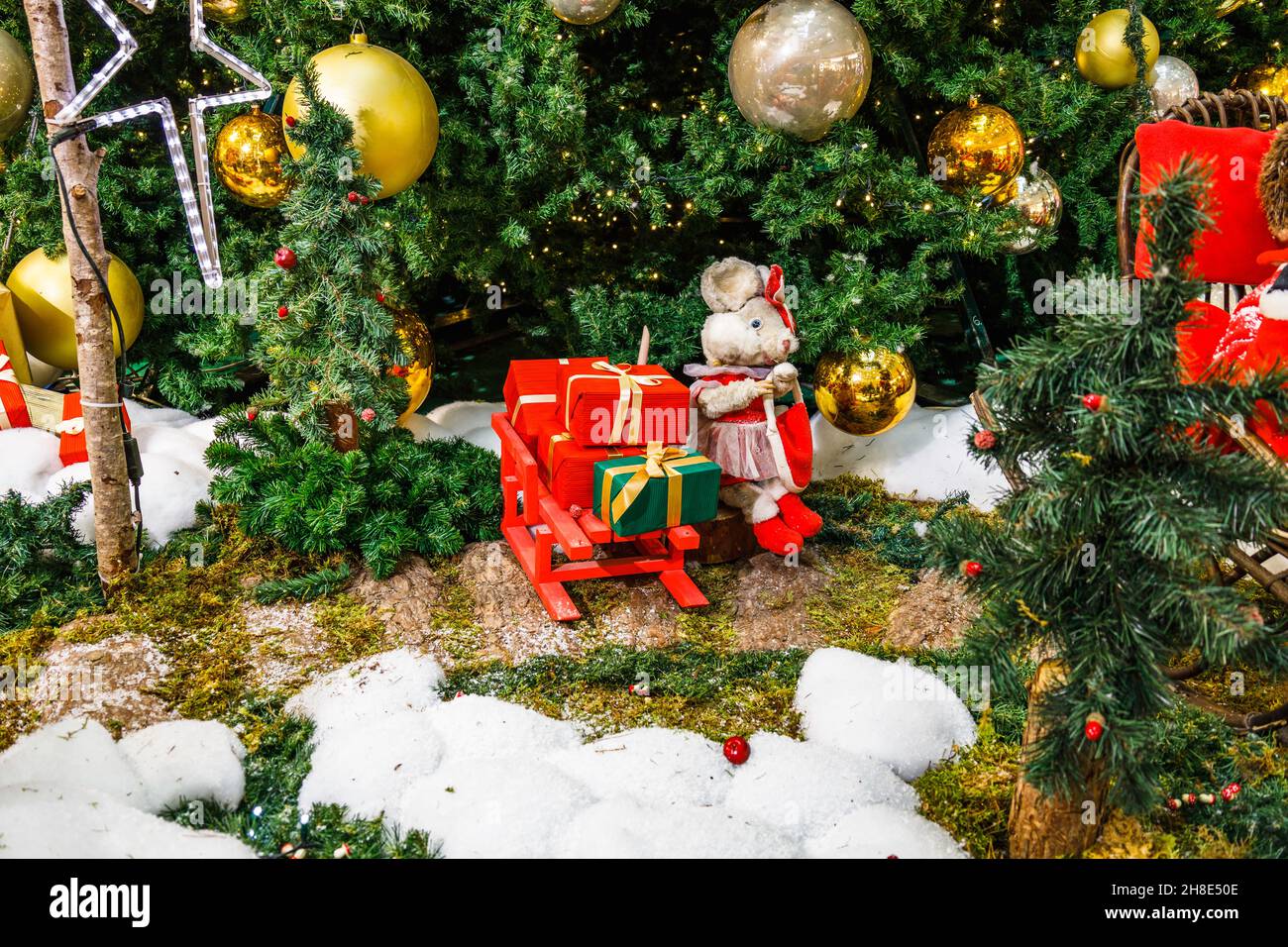 Decorazione di Natale con scatole regalo e personaggi di Natale sotto l'albero di abete Foto Stock