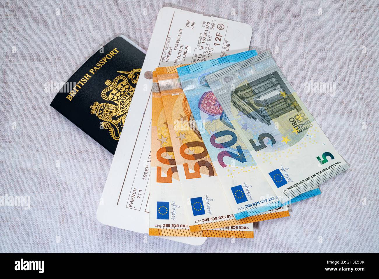 Passaporto britannico blu di nuovo stile con un biglietto di volo e denaro di viaggio Foto Stock