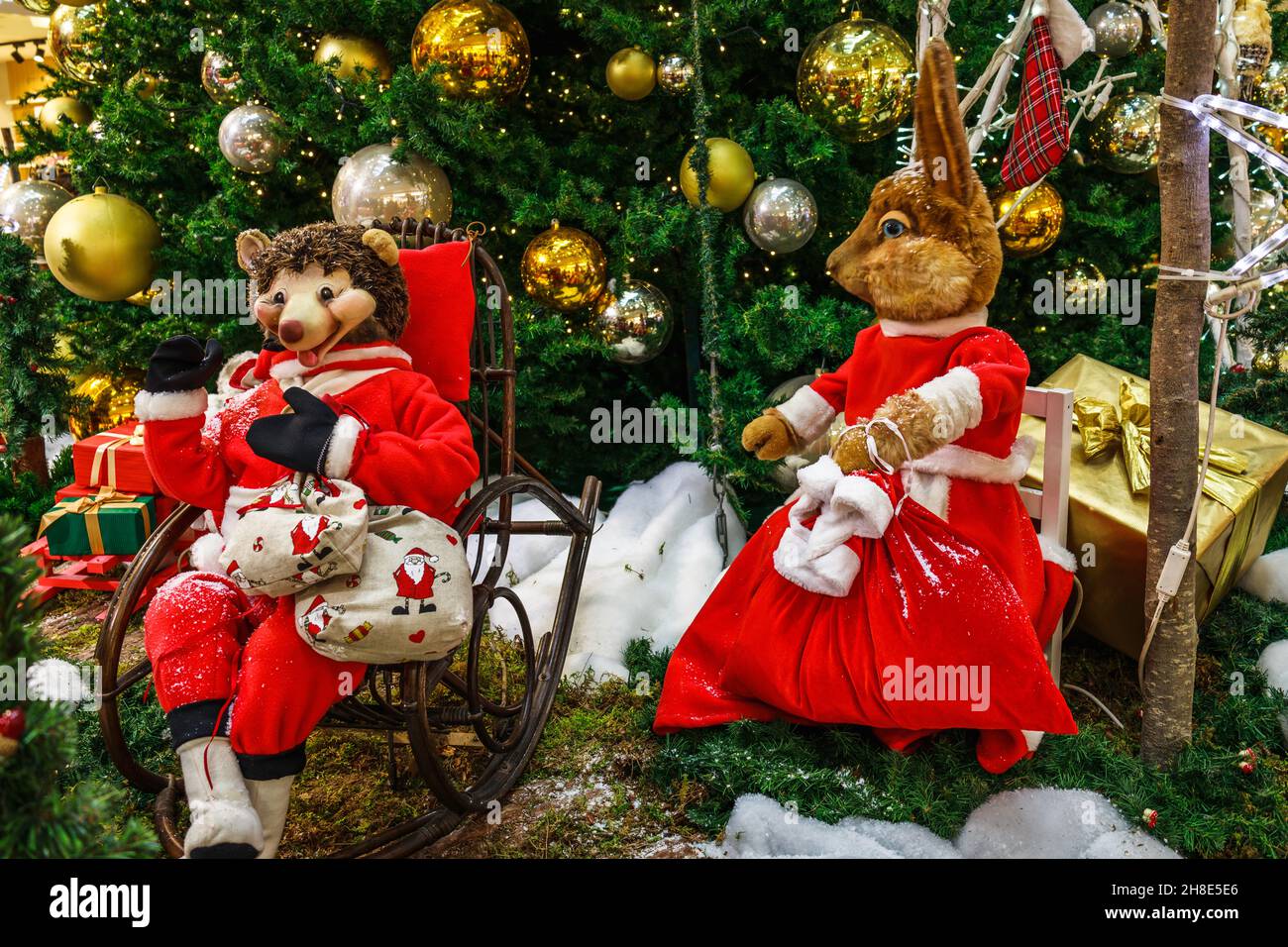 Decorazione di Natale con scatole regalo e personaggi di Natale sotto l'albero di abete Foto Stock