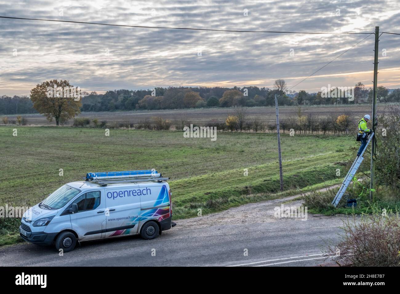 BT Openreach ingegnere che lavora su una linea nella campagna rurale del Norfolk. Foto Stock